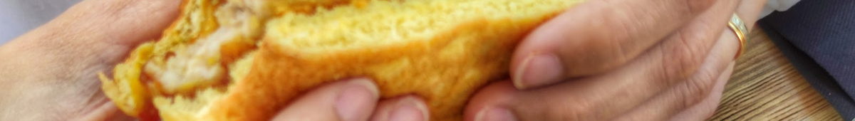 Dos manos sujetando la hamburguesa con el queso fundido