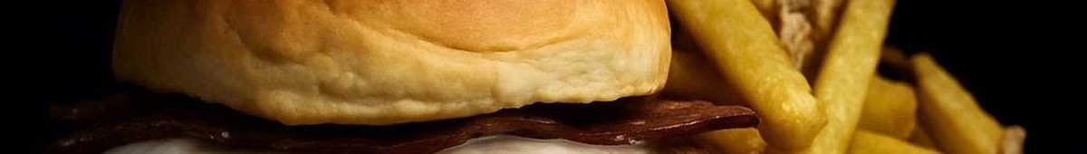 Hamburguesa con bacon y patatas sobre fondo negro